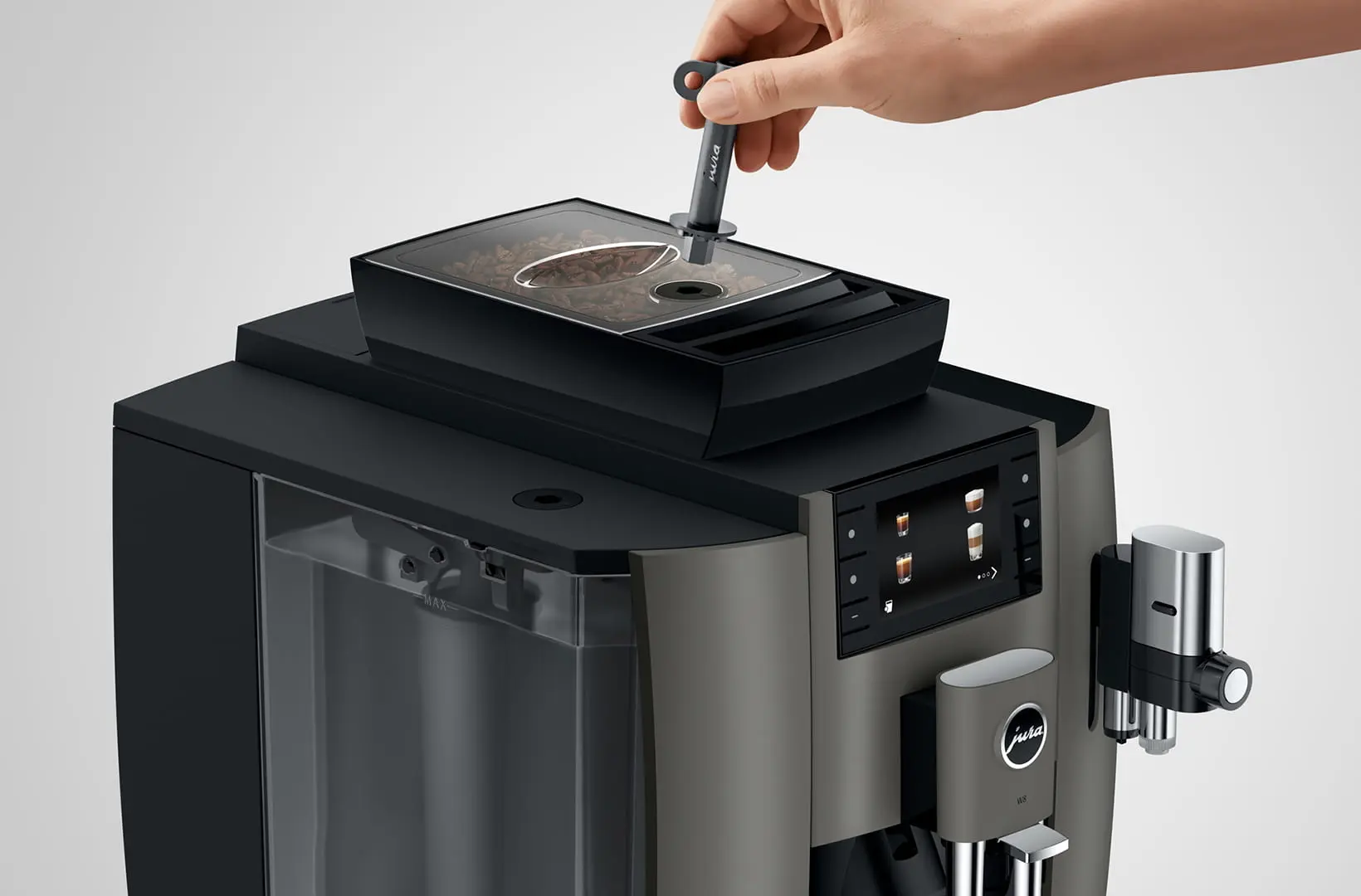 Utilisation de la clé de verrouillage sur le bac à grains de la JURA W8 Dark Inox pour sécuriser l'accès au café, idéale pour un usage en libre-service.